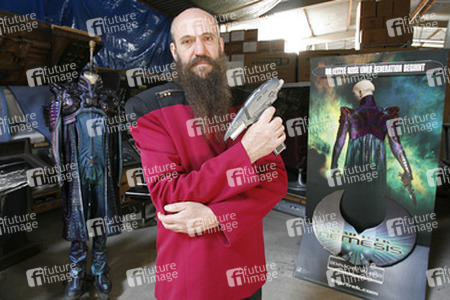 Martin Netter in Sternenflottenuniform mit Phaser. Im Hintergrund Originalkostüm aus 'Star Trek X'