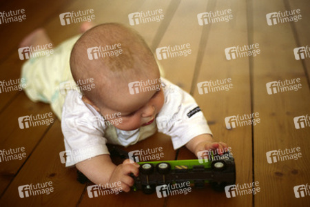 Baby mit Spielzeuglaster