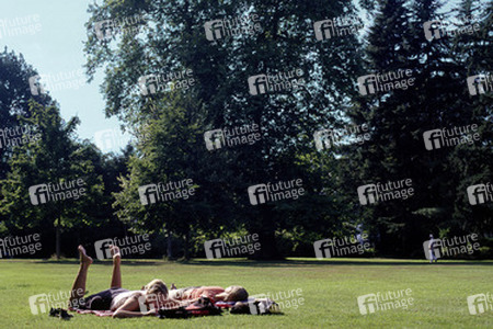 Zwei Frauen relaxen auf einer Parkwiese