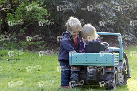 Kleinkinder mit Tretauto