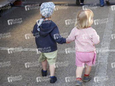Zwei Kinder Hand in Hand von hinten