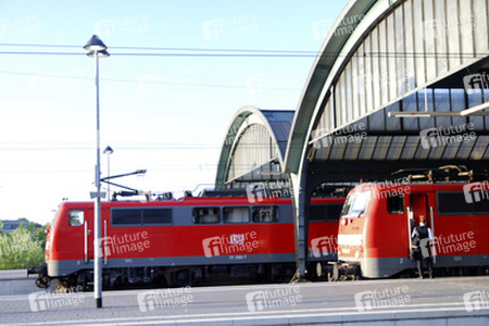 Zwei rote Lokomotiven im Bahnhof mit Zugführer
