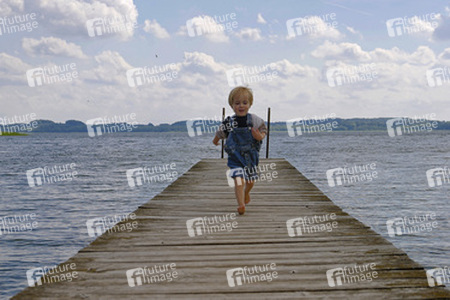 Junge rennt über einen Bootssteg