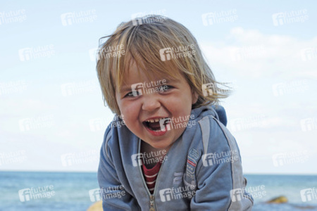 Kleines lächelndes Mädchen am Meer