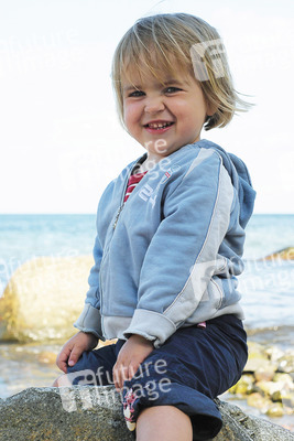 Kleines lächelndes Mädchen am Meer