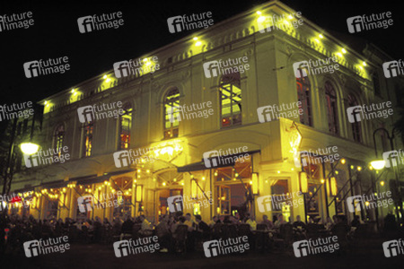 Ein vollbesetztes Straßencafé in der Nacht