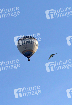 Motorlenkdrachen umkreist Heißluftballon