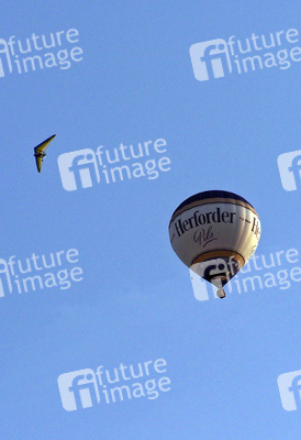 Motorlenkdrachen umkreist Heißluftballon