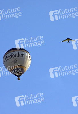 Motorlenkdrachen umkreist Heißluftballon