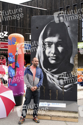 Victor Landeta präsentiert sein Mauersegment mit dem Porträt von Malala Yousafzai
