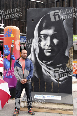 Victor Landeta präsentiert sein Mauersegment mit dem Porträt von Malala Yousafzai