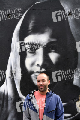 Victor Landeta präsentiert sein Mauersegment mit dem Porträt von Malala Yousafzai
