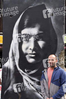 Victor Landeta präsentiert sein Mauersegment mit dem Porträt von Malala Yousafzai