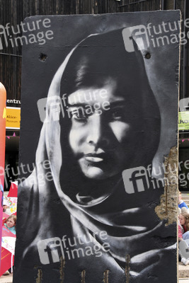 Victor Landeta präsentiert sein Mauersegment mit dem Porträt von Malala Yousafzai