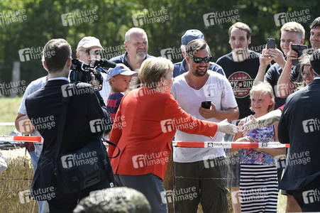 Angela Merkel besucht einen Milchbauernhof in Nienborstel