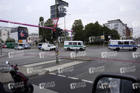 Einsatzfahrzeuge der Polizei unterwegs zu einer Razzia in Berlin