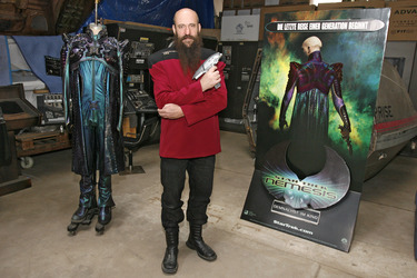 Martin Netter in Sternenflottenuniform mit Phaser. Im Hintergrund Originalkostüm aus 'Star Trek X'