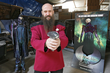Martin Netter in Sternenflottenuniform mit Phaser. Im Hintergrund Originalkostüm aus 'Star Trek X'