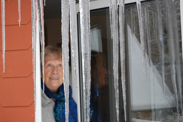 Alte Dame an vereistem Fenster