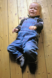 Weinender Junge auf Holzfußboden