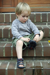 Junge zieht sich Schuhe an