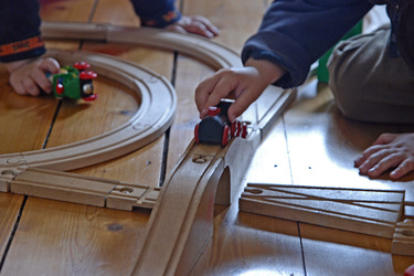 Spielzeugeisenbahn und Kinderhände