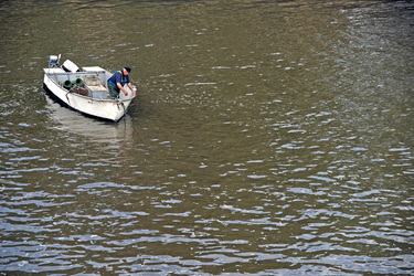 Fischer in kleinem Motorboot