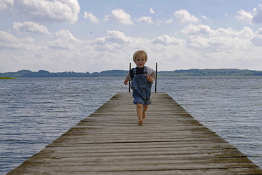 Junge rennt über einen Bootssteg