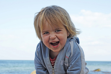 Kleines lächelndes Mädchen am Meer