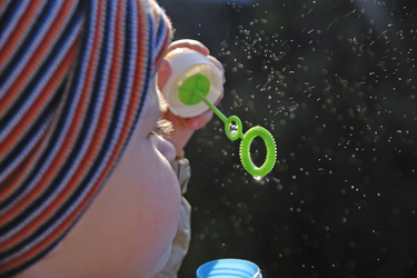 Kleines Mädchen macht Seifenblasen