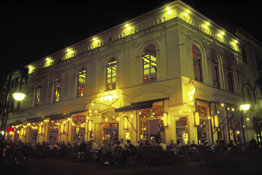 Ein vollbesetztes Straßencafé in der Nacht