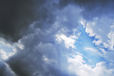 Blaue Wolken mit Sonnenstrahlen