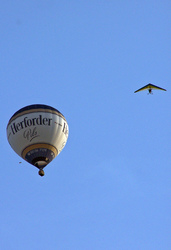 Motorlenkdrachen umkreist Heißluftballon