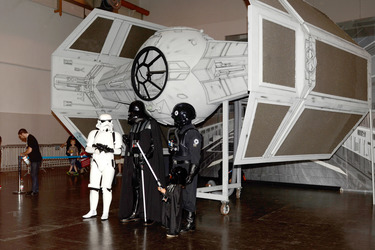 Star Wars Fans - Stormtrooper, Darth Vader und Pilot vor TIE-Fighter