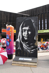 Victor Landeta präsentiert sein Mauersegment mit dem Porträt von Malala Yousafzai