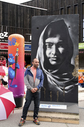 Victor Landeta präsentiert sein Mauersegment mit dem Porträt von Malala Yousafzai