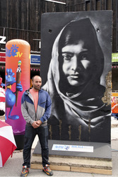 Victor Landeta präsentiert sein Mauersegment mit dem Porträt von Malala Yousafzai