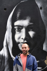 Victor Landeta präsentiert sein Mauersegment mit dem Porträt von Malala Yousafzai