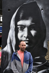 Victor Landeta präsentiert sein Mauersegment mit dem Porträt von Malala Yousafzai