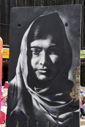 Victor Landeta präsentiert sein Mauersegment mit dem Porträt von Malala Yousafzai
