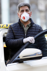 Symbolfoto Taxifahrer mit Schutzkleidung