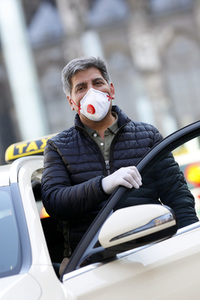 Symbolfoto Taxifahrer mit Schutzkleidung