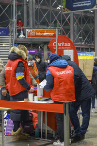 Caritas Mitarbeiter empfangen ukrainische Flüchtlinge in München