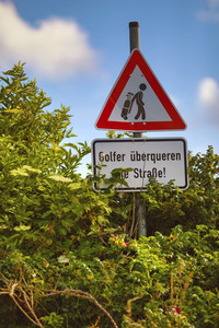 Symbolfoto Golfer überqueren die Straße