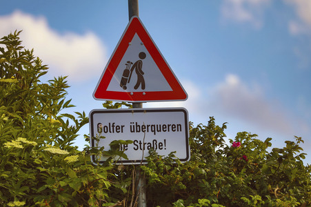 Symbolfoto Golfer überqueren die Straße